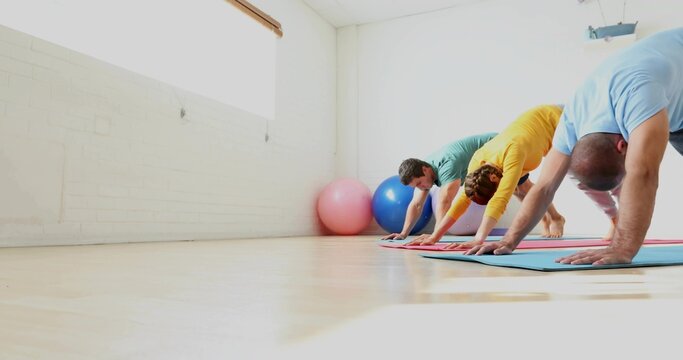 Stretching 3 adults folding on yoga mats in studio with stability balls in activewear, copy space - Powered by Adobe