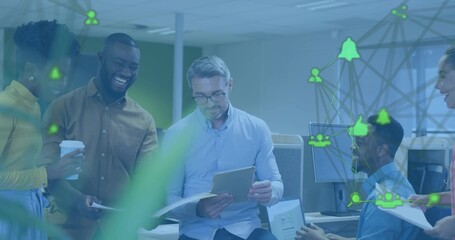 Discussing office team holding tablet, reviewing docs in open-plan workspace with plant, overlay