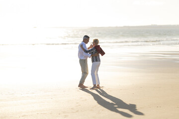 Senior couple dancing on beach celebrating love and happiness