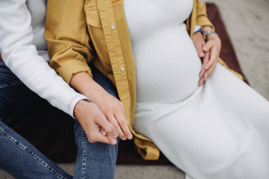 Pregnant couple holding hands anticipating new life together