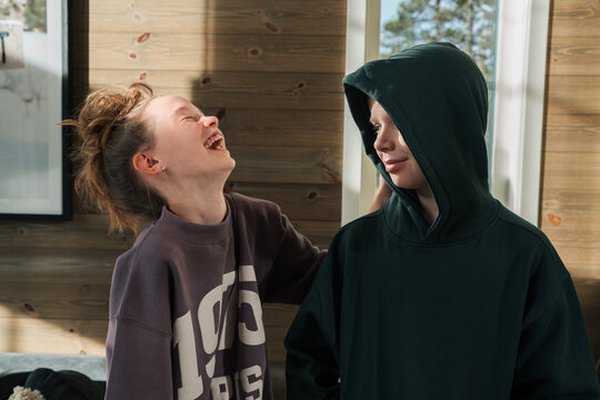 siblings laughing together playing around at home together