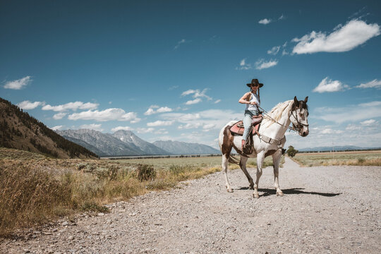 Cowgirl reigns in her horse while riding in Grand Teton National park
