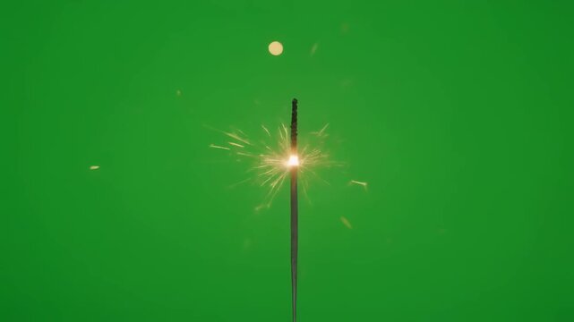 Sparkler firework exploding with bright golden sparks and light trails against a vibrant green screen background, perfect for celebrations and festive occasions