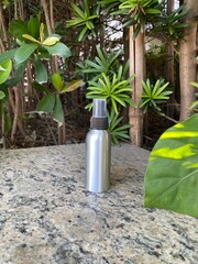 Spray Bottle on Stone Table with Garden Foliage