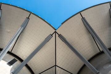 An innovative architectural design viewed from below against a vibrant blue sky, emphasizing the beauty of modern structures and their dynamic forms.