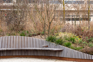 An artistic wooden bench beautifully integrated into a natural setting, emphasizing design and connection to nature in a serene landscape.