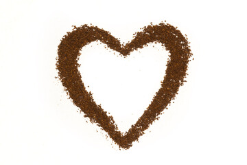Heart shape made of scattered ground coffee powder background
