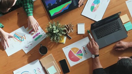 Top view of diverse businesspeople discuss about financial plan at meeting while looking at stock market statistic and explain marketing idea at meeting room. Creative startup concept. Convocation. - Powered by Adobe