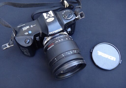 Olympus OM-101 film camera with Tamron lens on black background