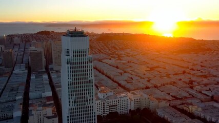 A tall woman stands on a rooftop, gazing out at the vibrant sunset lighting up the city. The sunset paints the skyline and reflects off the buildings, creating a beautiful view. - Powered by Adobe