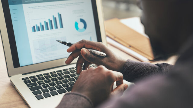 Businessman reviewing financial graphs on screen