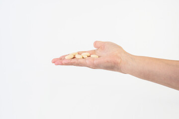 Medicine or vitamins in hand on white background