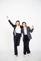 Two Asian women dressed in business attire posing on a clean white background, representing modern corporate roles, confident teamwork, and professional collaboration for office and company branding v
