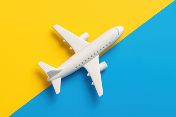 White toy airplane for travel on blue and yellow background. concept of hopeful support and flight for Ukraine