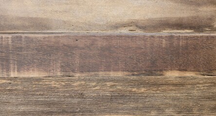 A rustic weathered wood plank background texture. Featuring varying light and dark brown tones with rich, detailed natural grain and a rough, distressed surface. Ideal for design backgrounds.