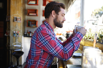 Calm, thinking or man in coffee shop with drink, mindset or satisfied in morning routine. Reflection, relax and male person in cafe with mug, mood improvement or mindfulness at start of day.