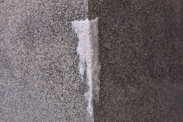 Rough, textured concrete wall details with distinctive white stains caused by efflorescence or salt...