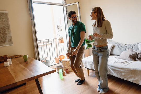 A man and a woman dance and smile while looking at each other - Powered by Adobe