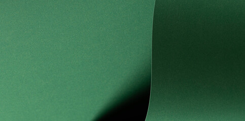 Deep emerald green paper background with a smooth texture and folds. Rich forest and pine tones