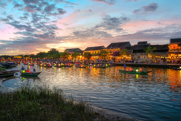 Fototapeta premium Hoi An, Vietnam at night and many tourists. Long-tail boats decorated with Vietnamese paper lanterns. A beautiful and important tourist attraction in Vietnam. Hoi An, Vietnam 