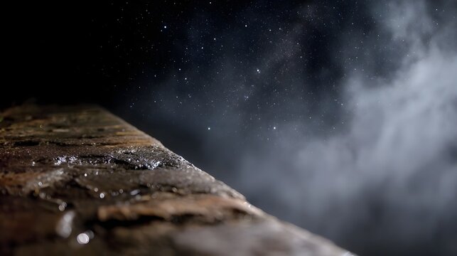 Close up of a wet ancient stone surface under a foggy starlit night sky creating a moody atmosphere