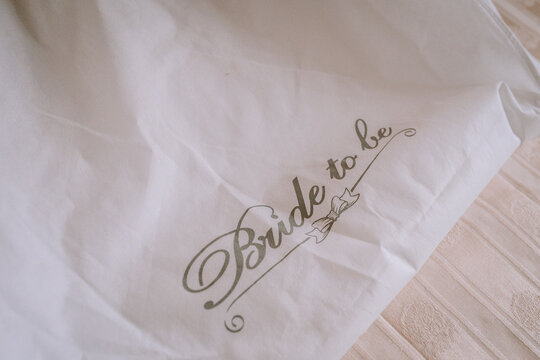 Elegant white fabric with delicate script reading "Bride to be," showcasing a soft texture and romantic ambiance, perfect for wedding celebrations and bridal events