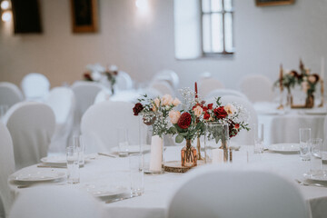Elegant table setting with floral arrangements, white tablecloths, and glassware, creating a romantic atmosphere for a wedding or special event celebration