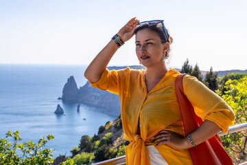 Woman travel sea, enjoying scenic coastal view from a cliffside viewpoint during summer vacation