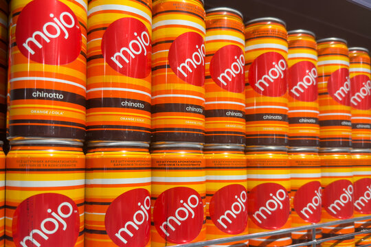 Poznan, Poland - November 22, 2025: Mojo Chinotto soda cans prominently displayed on a metal shelf, highlighting consumer beverage choices in a grocery store