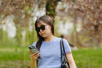 Female student standing and typing on phone