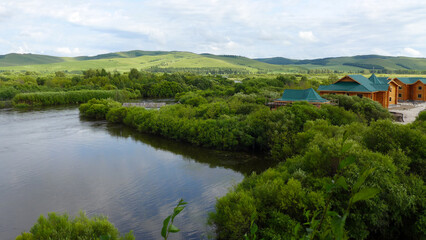 Wooden house beside winding river in the mountains