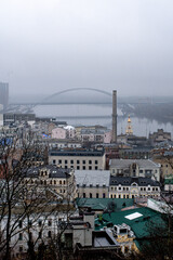 Foggy cityscape of Kyiv with bridge over the Dnipro River