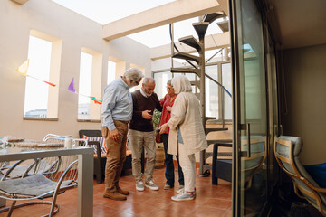 A group of four friends stand in a semicircle while one of them talks