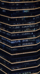 Multi-stories office building at night with worker working overtime. late night at office. lighting and working people within
