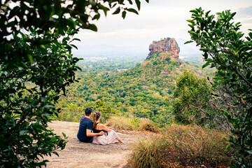 Couple in Sigiriya on honeymoon or family vacation. Woman and man on mountain in summer. Happy people and beautiful green landscape view. Tourism, romance and love. Tourists in Sri Lanka.
