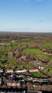 Portrait aerial drone footage of the town of Ripon in North Yorkshire in the UK showing typical British housing estates and streets along side the Yorkshire country side in the autumn time.