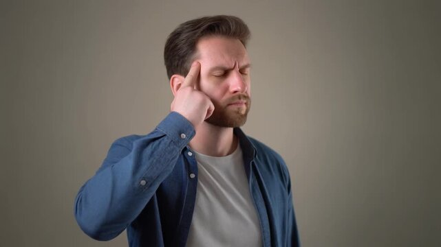 Thoughtful thoughtful man with closed eyes touching his temple with his index finger, contemplating a difficult idea or problem with a serious expression, subtle head movement