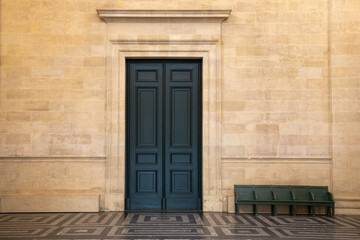 ancient wooden door large dark blue double access in a classical stone wall with a geometric floor in old french building