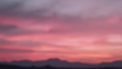 Fototapeta premium Vibrant Pink and Purple Sunset Sky Over Silhouetted Mountains.
