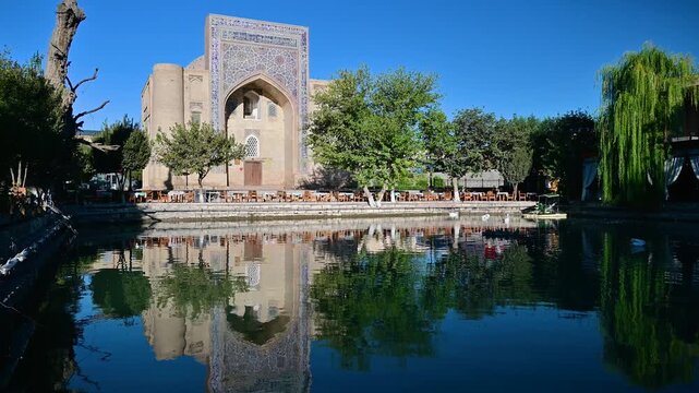 A view of the Nadir Divan Begi Khanaka at Lyabi Hauz in Bukhara, Uzbekistan, with tiled ornamentation and historic Islamic decorative elements.