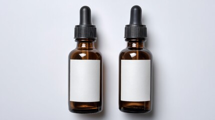 Two amber glass dropper bottles with white labels, against a plain white background, top-down