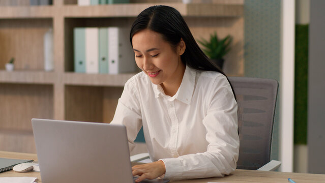 Positive Asian Japanese girl office worker employer HR manager business woman joyful Korean female businesswoman talking online video call computer laptop meeting interview recruiting indoors company