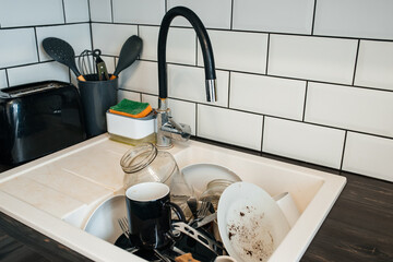 a full sink of dirty dishes before cleaning