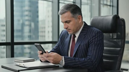 Professional man in grey suit checking phone inside bright modern business office corridor - Powered by Adobe