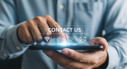 Close up of a man using a smartphone with the words contact us and related icons on the screen display
