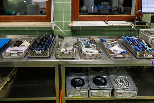 A row of organized surgical instrument trays prepared in a hospital sterilization department.