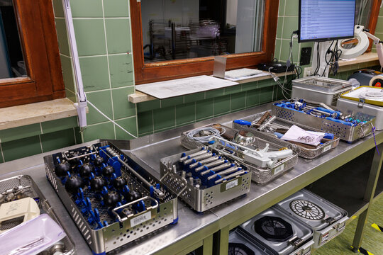 A row of organized surgical instrument trays prepared in a hospital sterilization department.