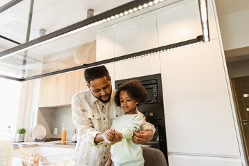 Father holding his daughter's hand and adjusting her sweatshirt