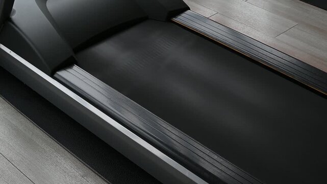 Electric treadmill belt running on a low speed setting, creating a steady motor hum and rhythmic belt whirring sound.