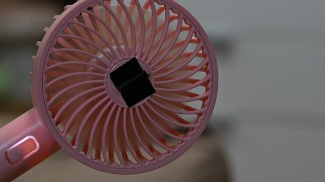 Portable fan running on high speed, creating a loud motor whining and fast air rushing sound.